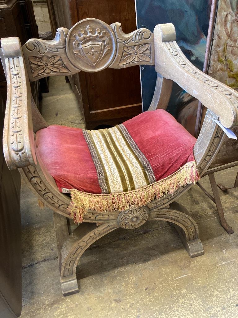 An 18th century style carved X frame oak chair, width 59cm, depth 49cm, height 77cm